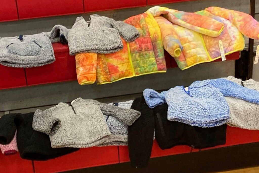 Colorful and gray winter coats on bench