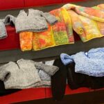 Colorful and gray winter coats on bench